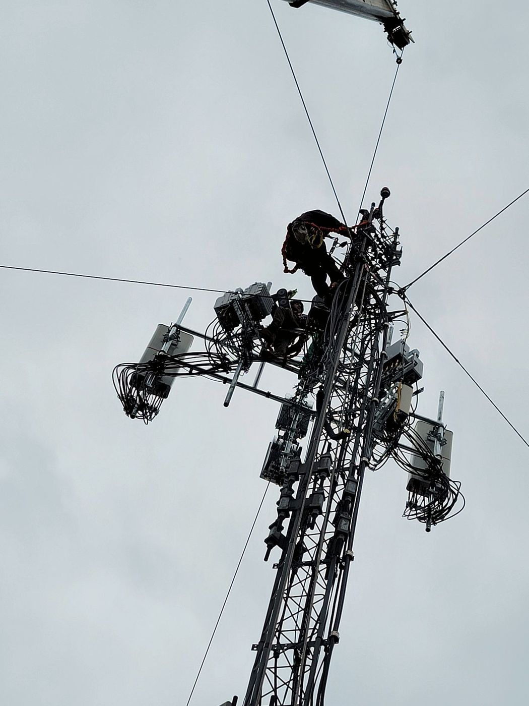 Tower technicians installing radios and antennas at the top of a tower