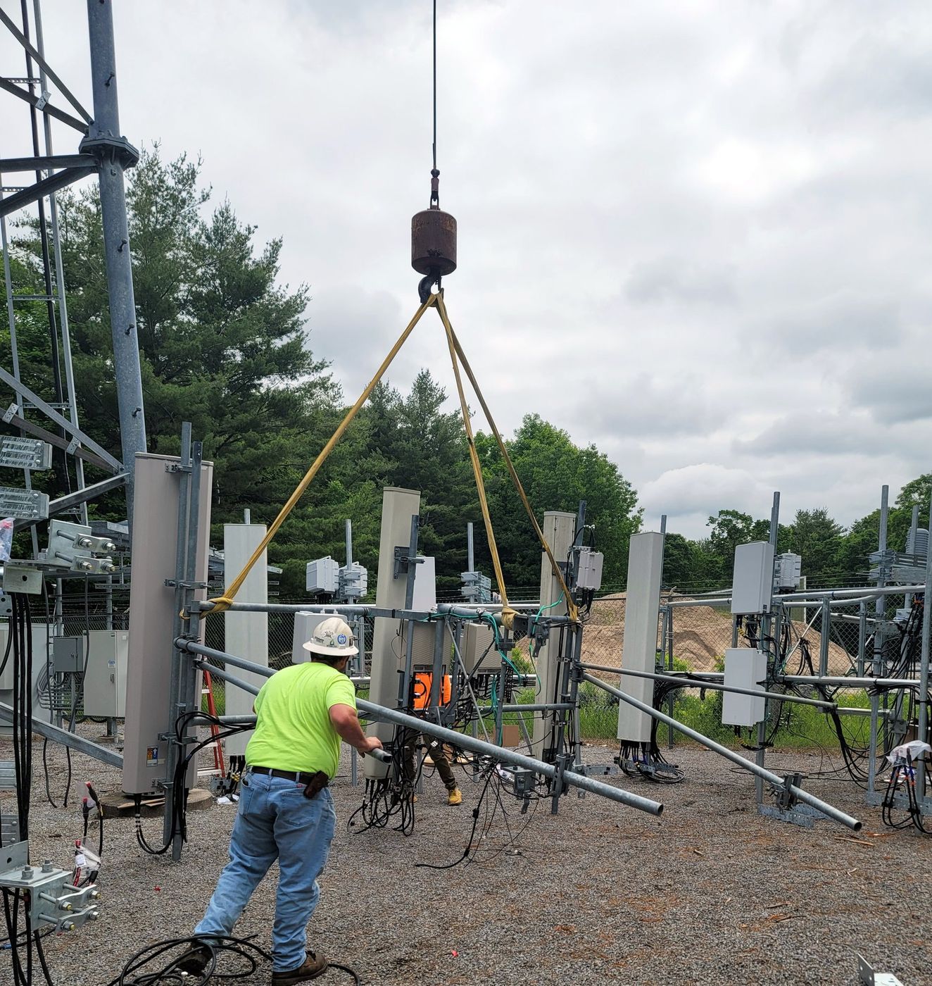 Triple Connect crew member in PPE guiding a crane lift at a wireless site build